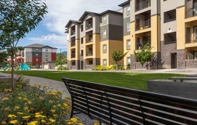 a park bench in front of an apartment complex