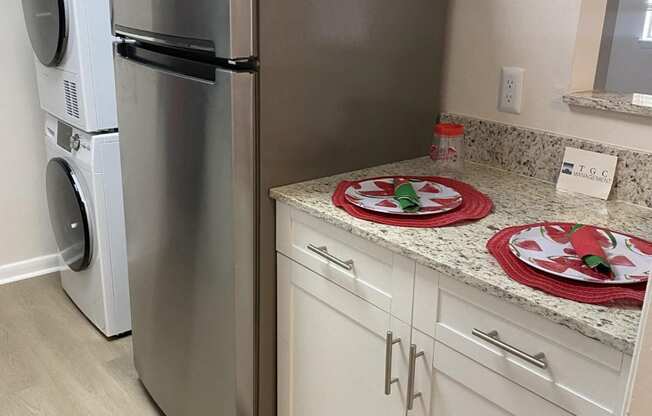 a kitchen with a counter and a refrigerator and a washing machine