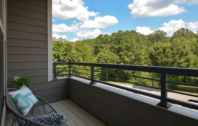 a balcony with a chair and a view of the woods at The Tribute, North Carolina, 27612
