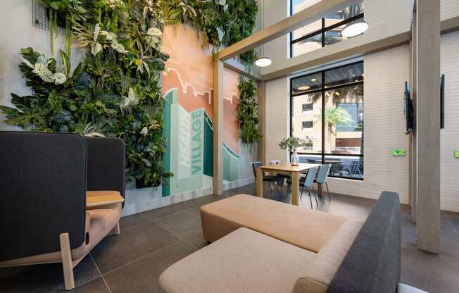 a living room with couches and a table and a wall of plants