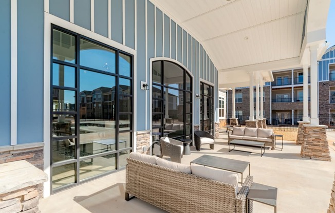 a covered patio with furniture and glass doors