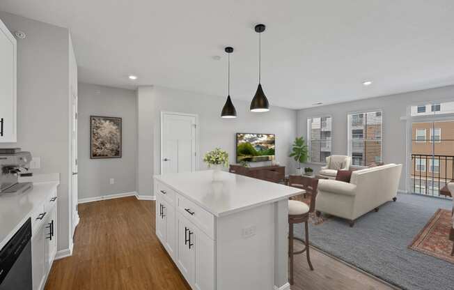 an open kitchen and living room with white cabinets and a white counter top