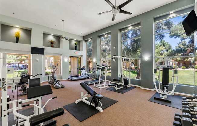 A spacious gym with a variety of equipment and a view of the outdoors.