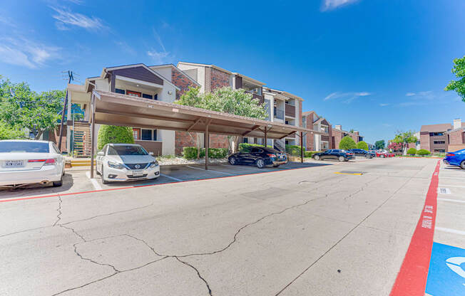 A parking lot with cars and a building in the background.