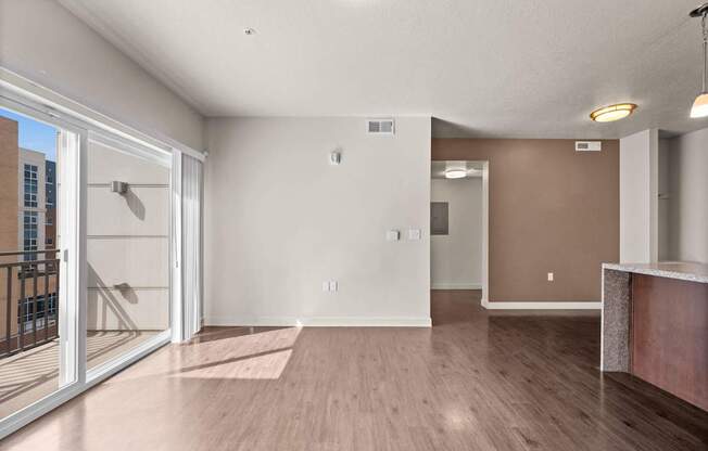 a living room with hardwood floors and a glass sliding door to a balcony at Wilmington Flats Apartments, Salt Lake City, Utah