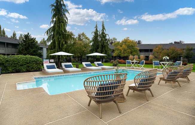 A pool area with sun loungers and trees.