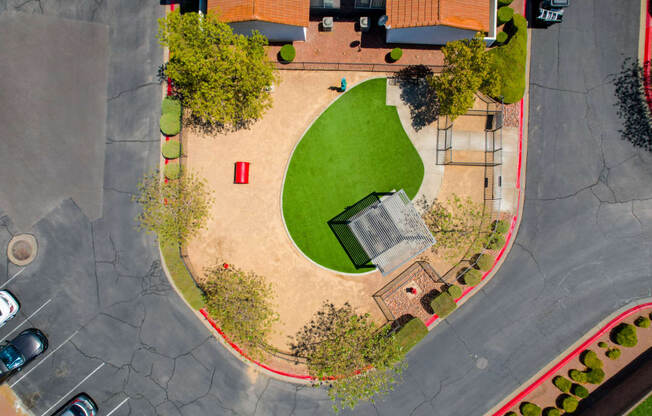 A park area with a green hill and a playground.