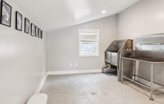 A room with a bed, a window, and pictures on the wall.