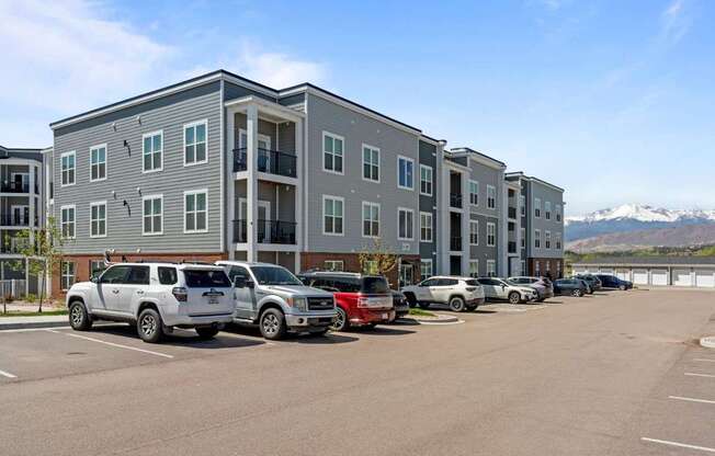 A parking lot with cars and a building in the background.