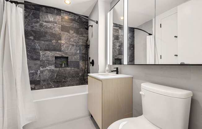 a bathroom with a toilet and a shower and a sink at The Paxton, Brooklyn