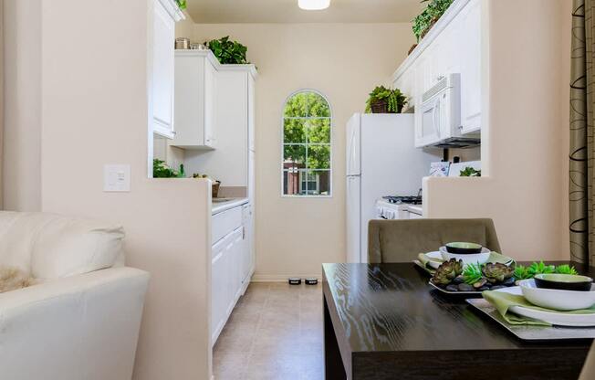 A kitchen with white cabinets and a black table.