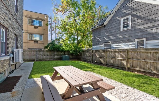 the backyard with a picnic table and a privacy fence