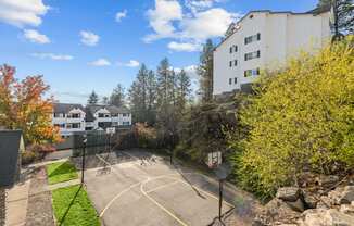 the view of a basketball court with a building in the background