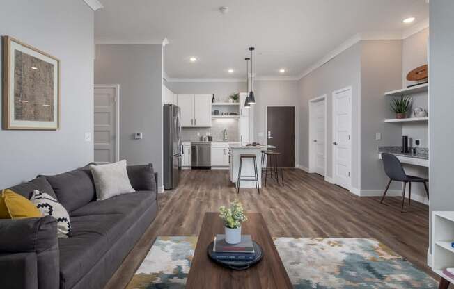 A modern living room with a grey couch and a coffee table in the center.