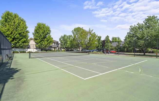 a tennis court at the whispering winds apartments in pearland, tx