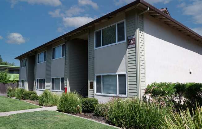 View of exterior building at Villas at Fair Oaks with lush shrubbery surrounding building