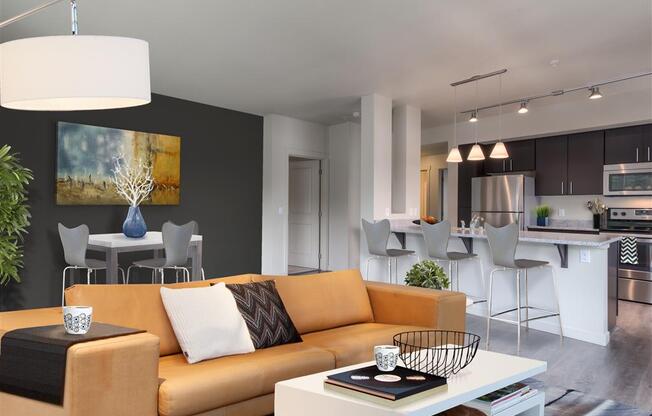 A modern living room with a sofa, coffee table, and kitchen area. at Kirkland Crossing Apartments, Kirkland, WA, 98033