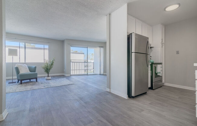 an open living room and kitchen with a stainless steel refrigerator at Citra Apartments LLC, San Diego, CA, 92107