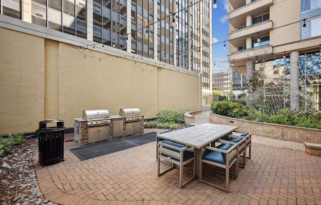A patio with a table and chairs is surrounded by a brick wall.