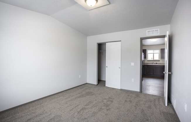 Bright, vacant bedroom with neutral walls and carpet flooring.