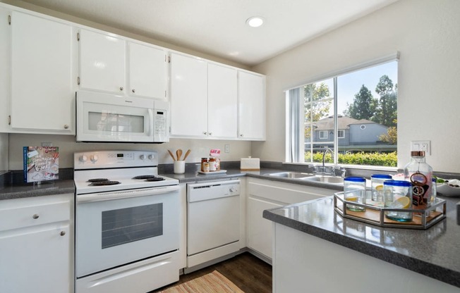 a kitchen with white appliances and granite counter tops