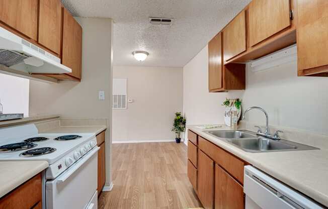 galley kitchen with wood finishes and white appliances  at Arbors Of Cleburne, Cleburne