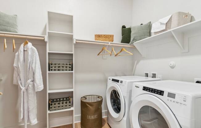 a laundry room with a washer and dryer and a closet with shelves