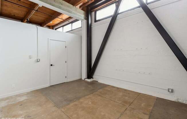 A room with a white wall and a brown floor.