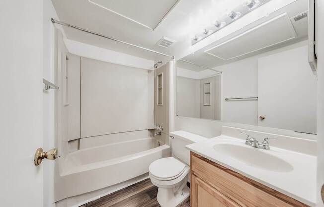 A white bathroom with a toilet, sink, and bathtub.