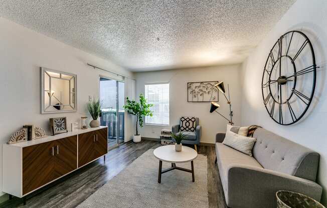 a living room with a couch and a clock on the wall