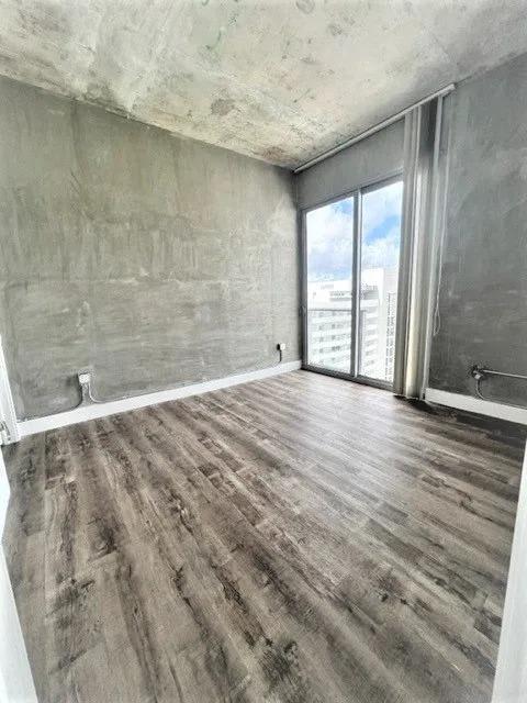 a living room with a wooden floor and a window