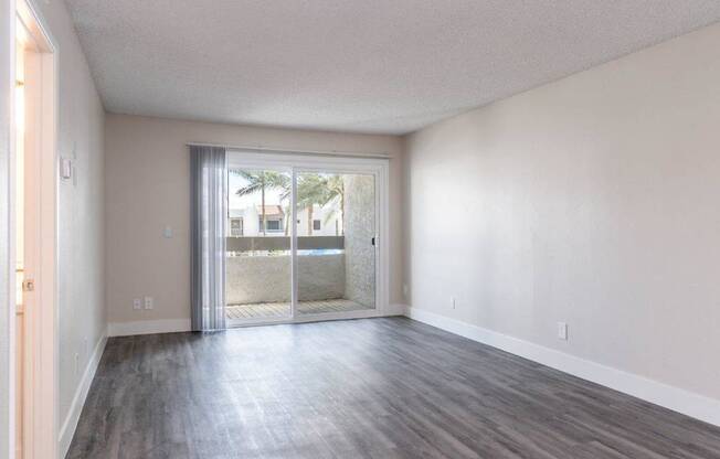 A room with a sliding glass door leading to a balcony.