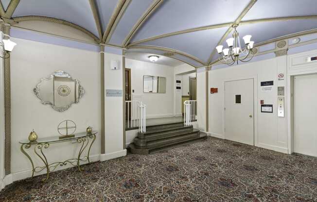 a large lobby area with blue vaulted ceilings with intricate gold detailing and a chandelier at Stockbridge Apartment Homes, Washington, 98101