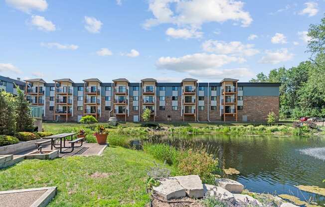A row of modern townhouses with a pond in front.