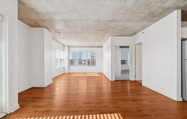 A long hallway with a wooden floor and white walls.