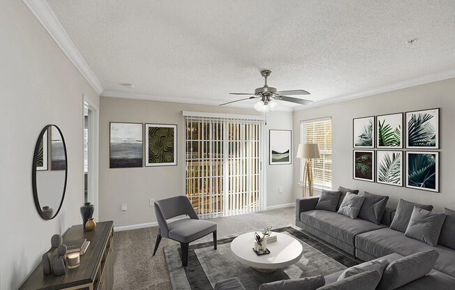 Model Living Room with Carpet and Patio Accessibility at Shadow Ridge Apartments in Riverdale, GA.