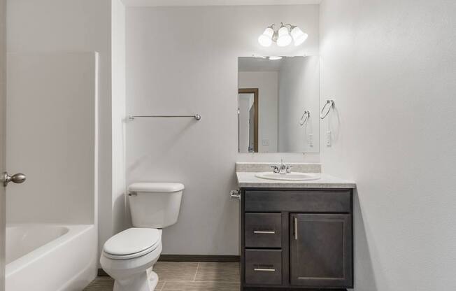 A white toilet sits next to a sink in a bathroom.