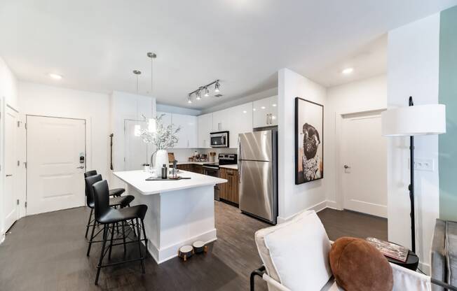a kitchen with a white counter top and a stainless steel refrigerator