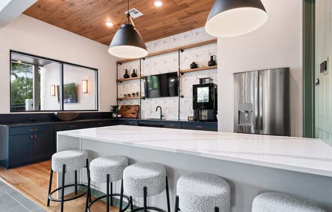 a kitchen with a large white counter top and bar stools