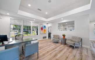the living room of a home with a desk and chairs