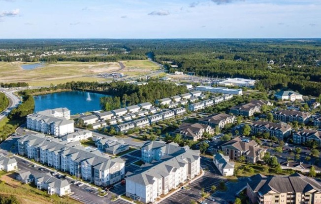an aerial view of a large apartment complex with a lake in the background