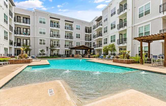 A large swimming pool in front of apartment buildings.