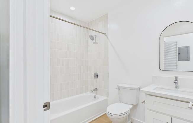A white bathroom with a toilet, sink, and bathtub.