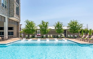 a swimming pool with lounge chairs and a building in the background