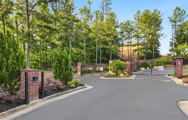 a large driveway with a brick fence and brick pillars