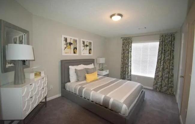 a bedroom with a bed and a dresser and a window  at The Sapphire, Georgia, 30035