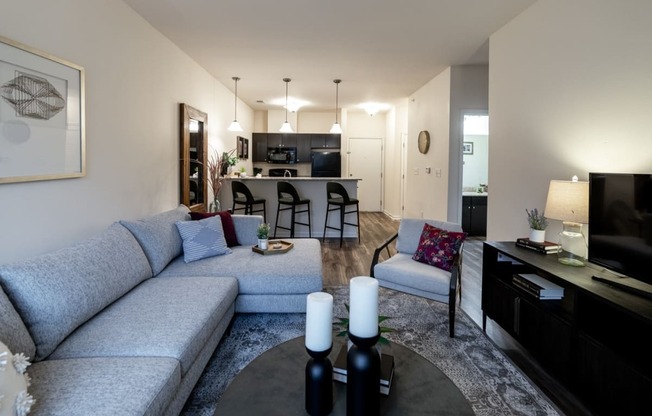 a living room and kitchen with a couch and a table at 310 at Nulu Apartments-Student, Louisville, 40202