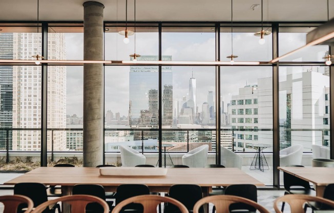 a view of the city from a restaurant with a table and chairs at The Lively, Jersey City New Jersey