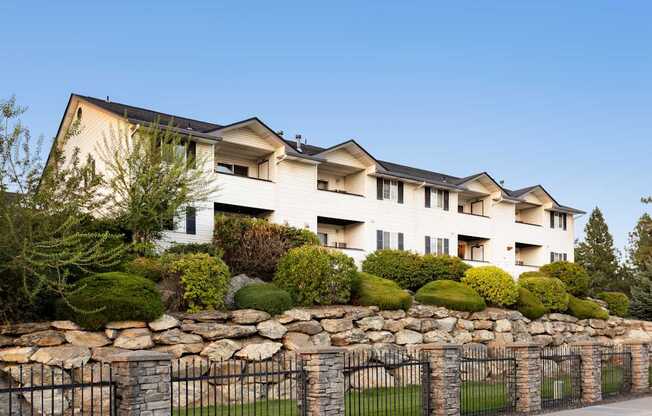 A large white building with a black fence in front.