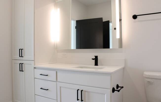 a small bathroom with white cabinets and a white toilet